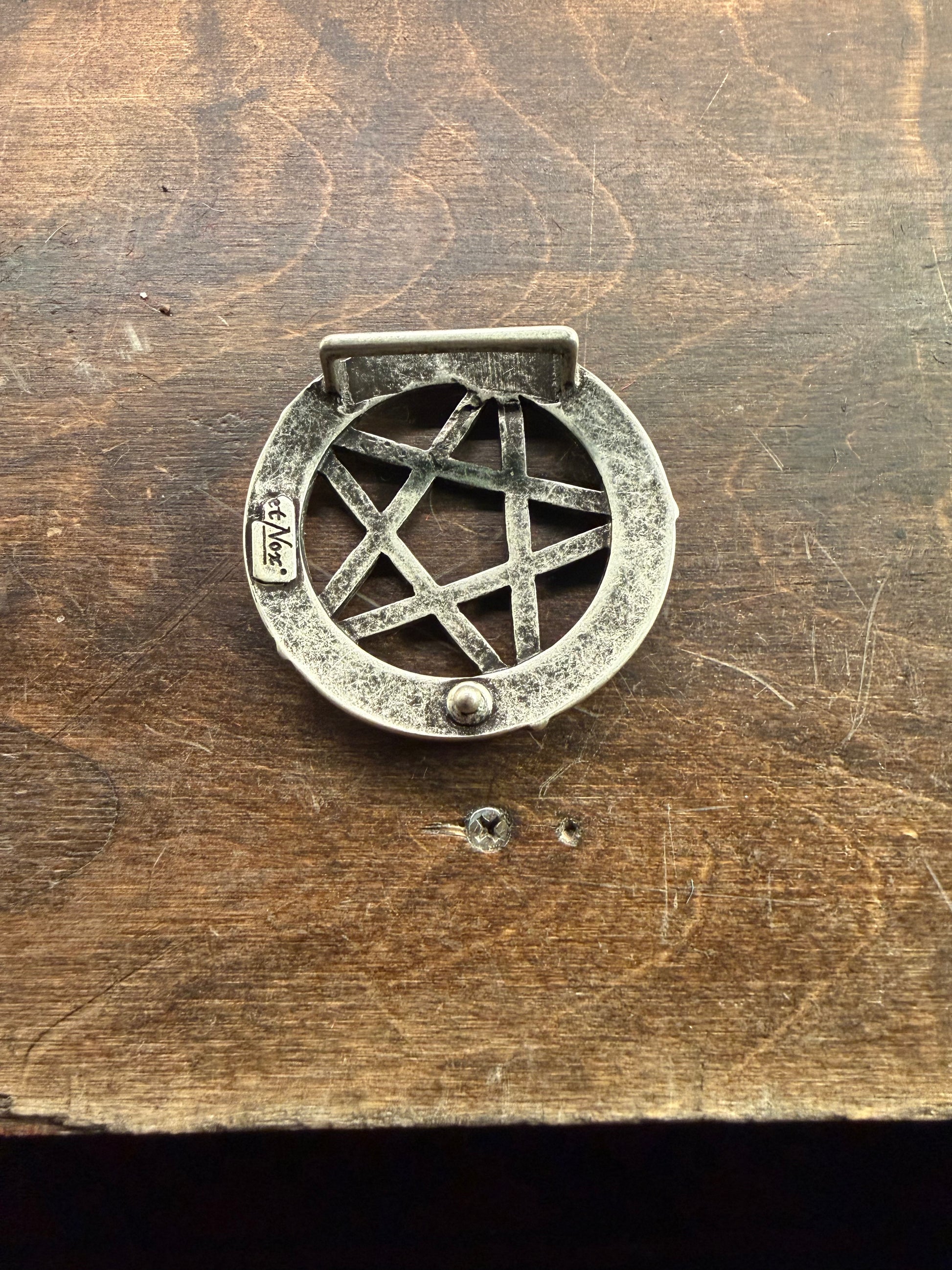 Svart spänne med pentagrammönster från Hellgate, dekorativ bältesspänne i metall.